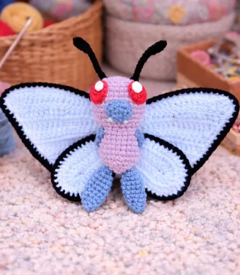 Butterfree crochet amigurumi pattern with blue wings and black edging
